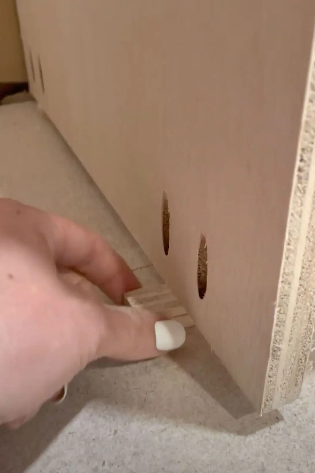 Using a shim to raise the height of the cabinet off of the floor.